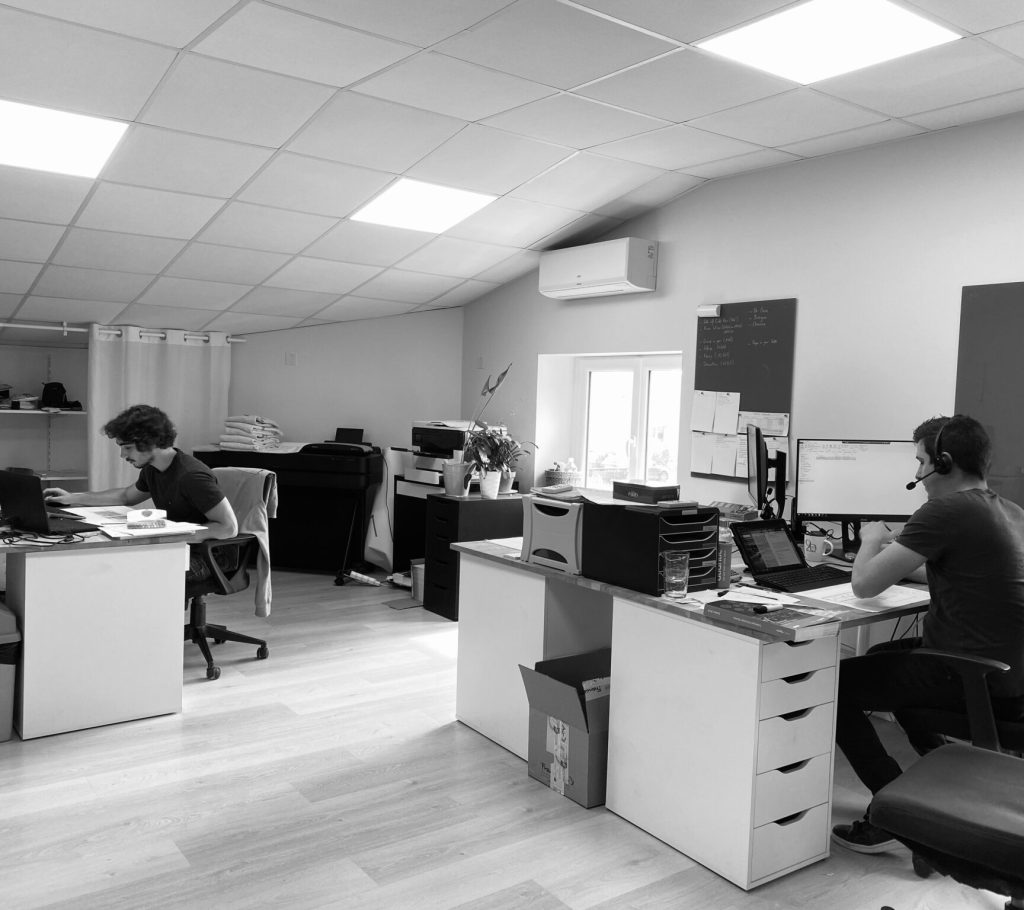 bureaux disposes en open space avec deux salaries travaillants sur leurs ordinateurs